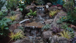 This landscaping water feature has a three-tiered waterfall with plantings