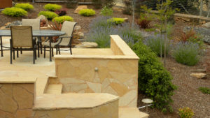 An Arizona 'Buckskin' patio with seat wall and steps down to a Mediterranean garden