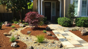 A dry creek bed installed next to a tile entry