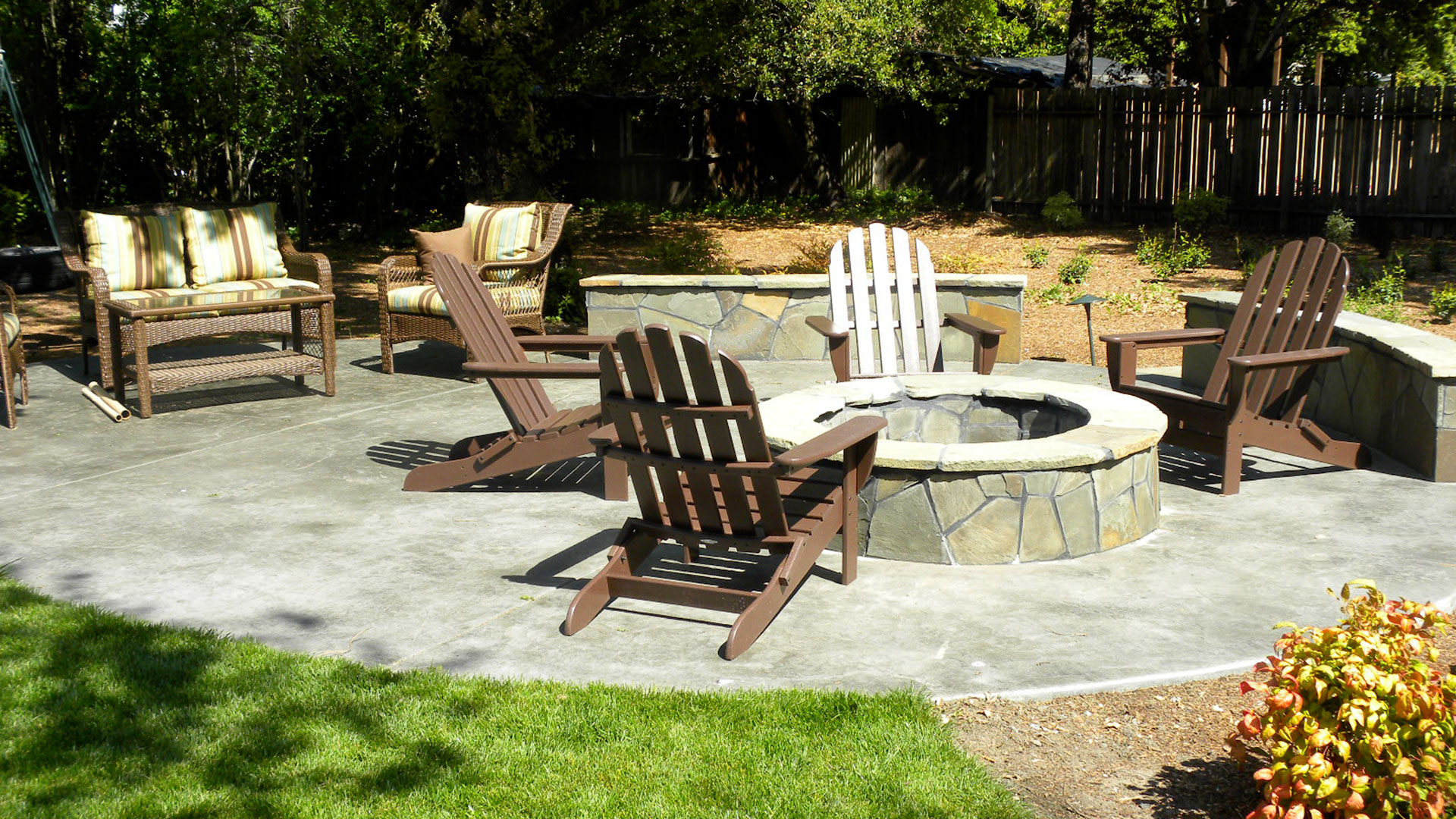Stamped concrete patio featuring flagstone seat wall and fire pit